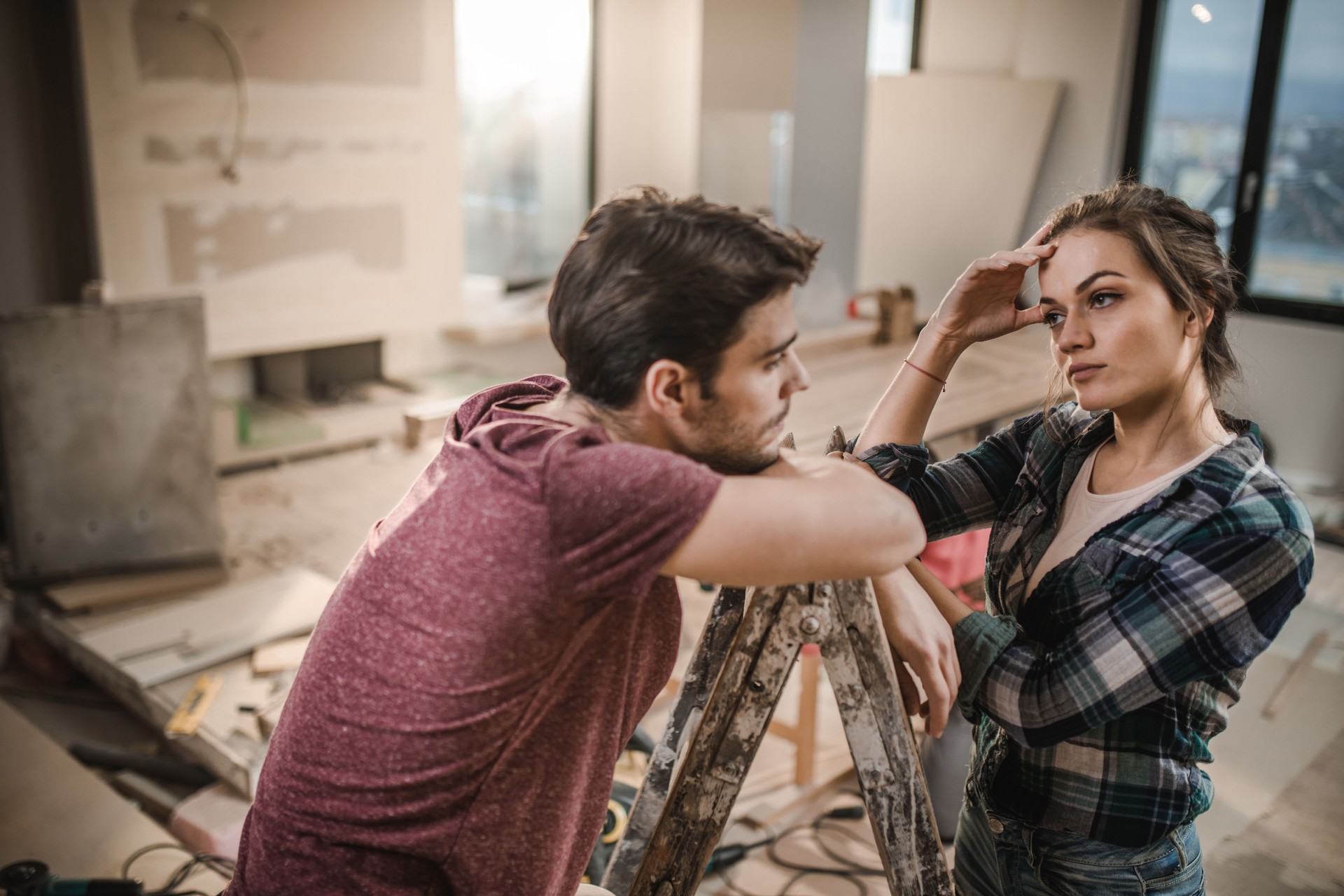 Young couple worrying about renovation of their apartment.